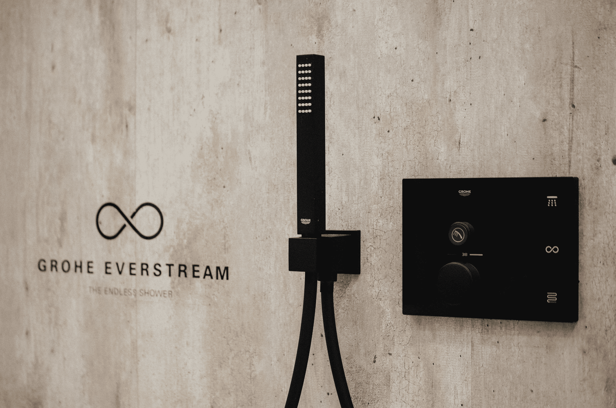 Grohe präsentiert die neue Technologie der Everstream Dusche mit schwarzen Armaturen die Wasserverschwendung minimiert.