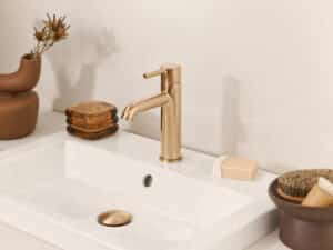 HANSA präsentiert den Wasserhahn mit Drehhebel aus gebürsteter Bronze der Serie Viva mit passender Abflussabdeckung.