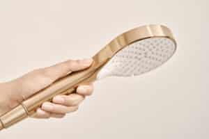 HANSA präsentiert die Handbrause mit rundem Kopf aus gebürsteter Bronze der Serie Viva.