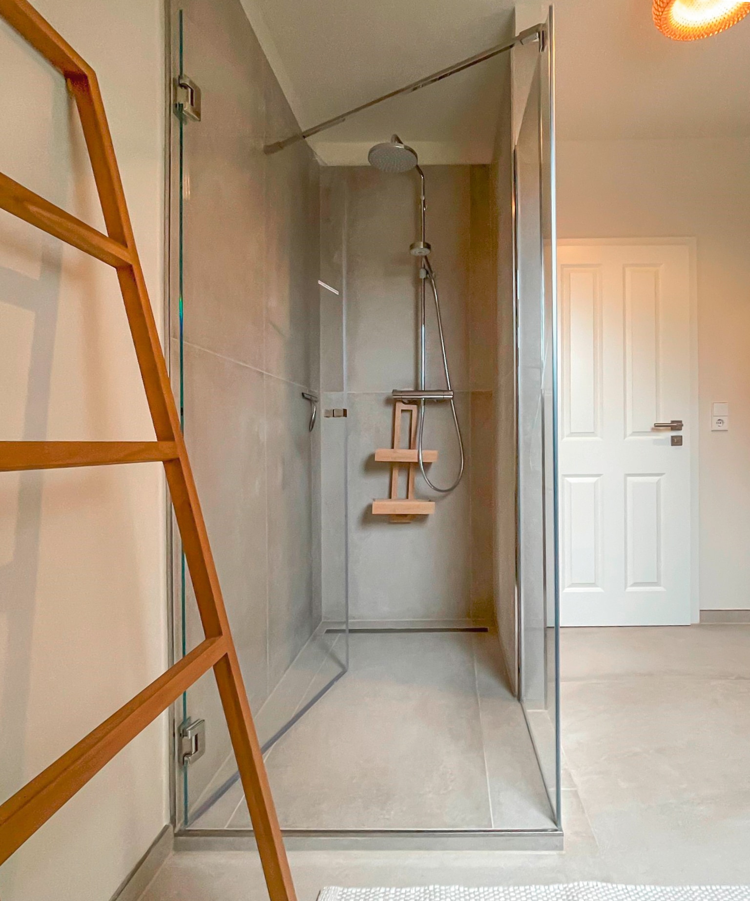 Hansa zeigt eine Regendusche und eine Handdusche, beide mit rundem Kopf und in silber, in einem Badezimmer eines Hotels.