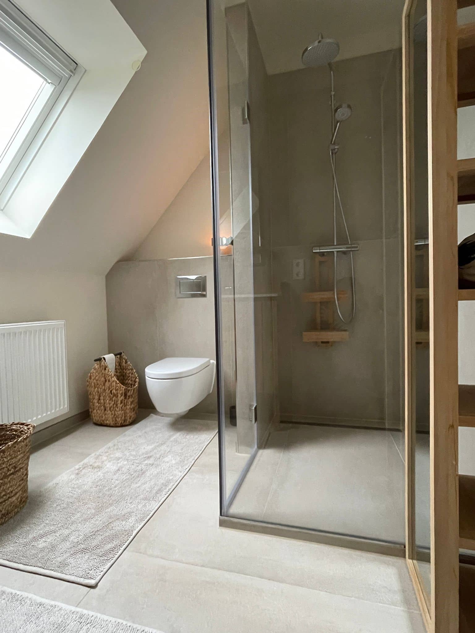 Hansa zeigt eine Regendusche und eine Handdusche, beide mit rundem Kopf und in silber, in einem Badezimmer eines Hotels.