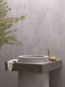 Hansa präsentiert eine elegante Armatur in gold mit obenliegendem Hebel und freistehend neben dem Beckenrand.