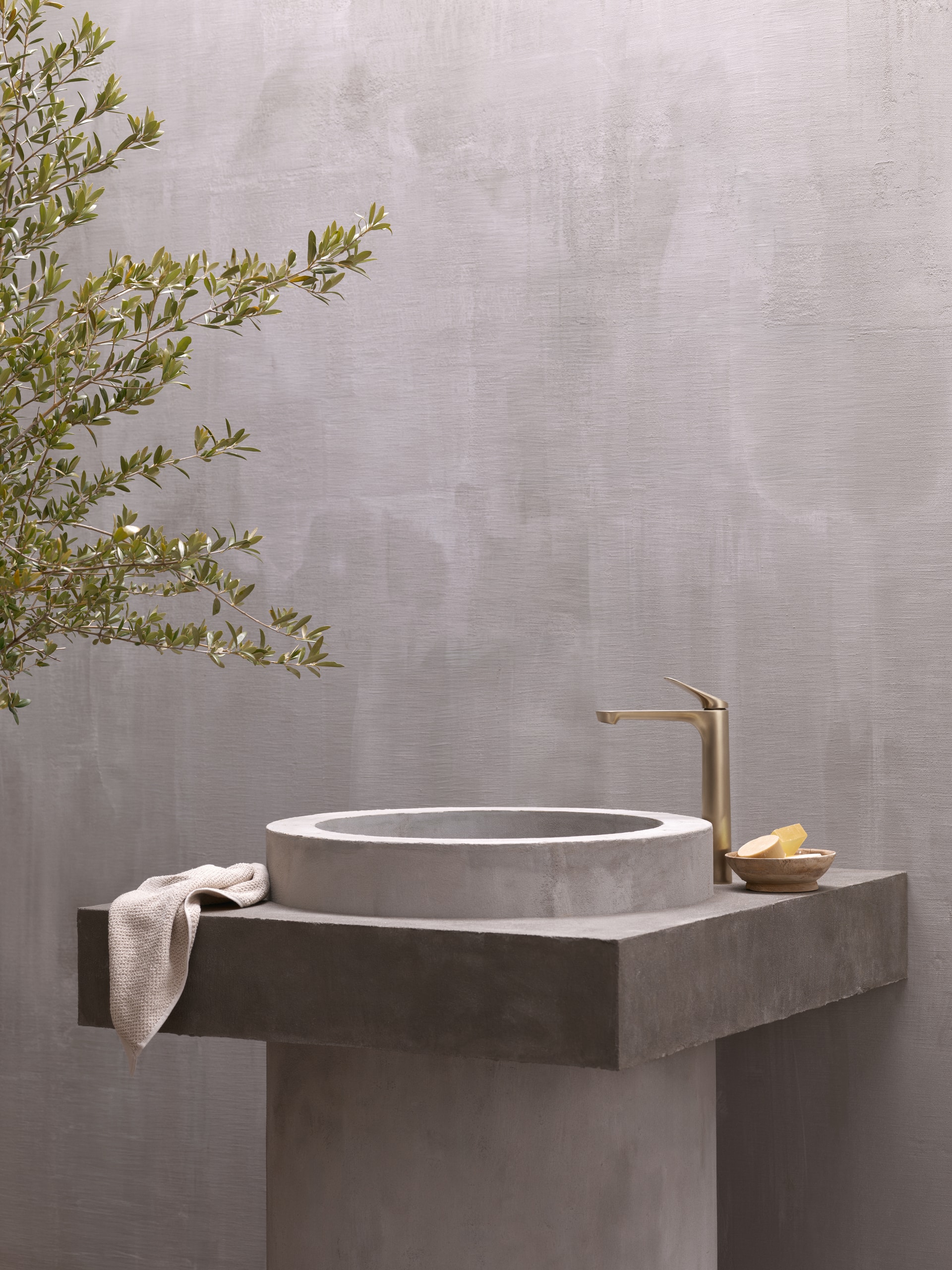 Hansa präsentiert eine elegante Armatur in gold mit obenliegendem Hebel und freistehend neben dem Beckenrand.