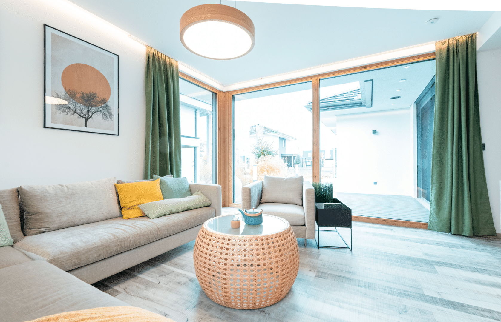 Hartl Haus zeigt ein Wohnzimmer mit großer, gemütlicher Sitzgelegenheit und um die Ecke reichenden, deckenhohen Schiebetüren zur Terrasse hin.