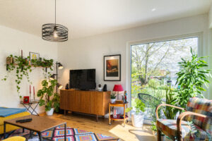 Ein Wohnzimmer mit bodentiefem Glaselement von HARTL HAUS.