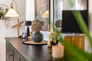 Eine Kommode im Wohnbereich mit Dekoration, Bildern, Lampen und Pflanzen in Nahaufnahme von HARTL HAUS.