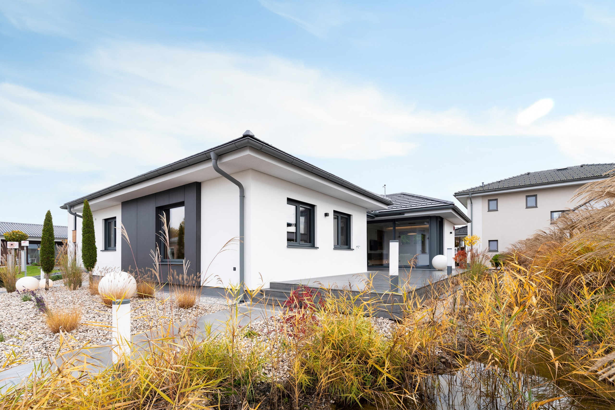 Der Bungalow Elegance 128 W von HARTL HAUS mit moderner Architektur und eleganter Fassadenelementen.