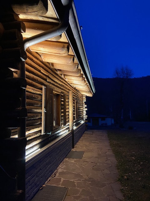 HAWO zeigt ein Holzhaus, dessen Holzfassade bei Nacht indirekt beleuchtet wird.