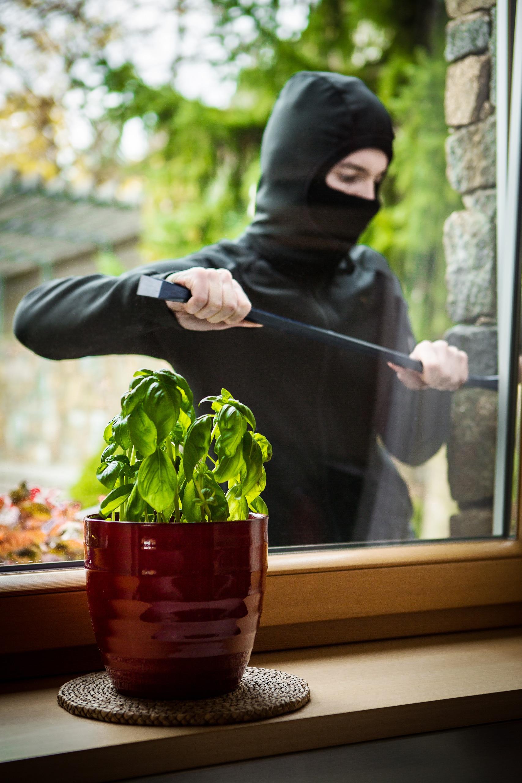 Darstellung eines typischen Einbruchs durch ein Fenster im Haus zur Verdeutlichung der Sicherheitsrelevanz von Alarmsystemen von Heimdall Alarmsysteme.
