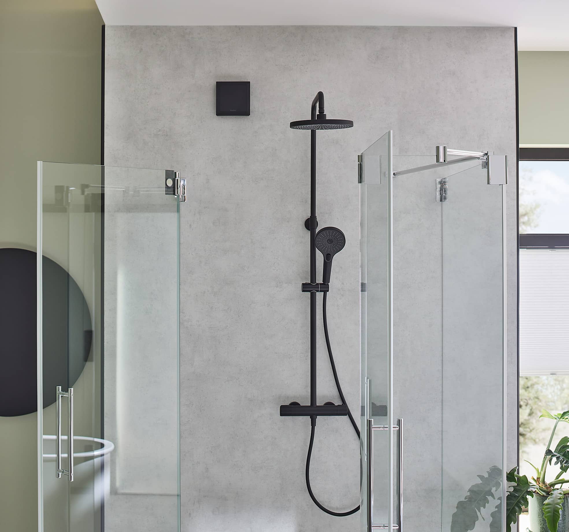 Helios präsentiert ein Badezimmer mit Duschkkabine, das mit dem neuen Designlüftungsventil in Schwarz ausgestattet ist.