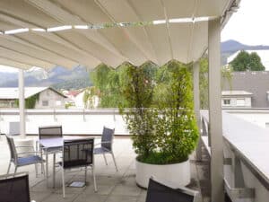 Dachterrasse mit freistehender Pergola mit Faltdach der Marke Gibus Typ Isola Fly gezeigt von HELLSAN.