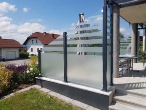 Erhöhte Terrasse mit Glasgeländer und seitlichem Sicht- und Windschutz aus satiniertem Glas von Glaserei Hohl.