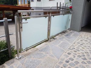 Hauseinfahrt mit einer Durchgangstüre, Alugeländer und Einsätzen aus satiniertem Glas von Glaserei Hohl.