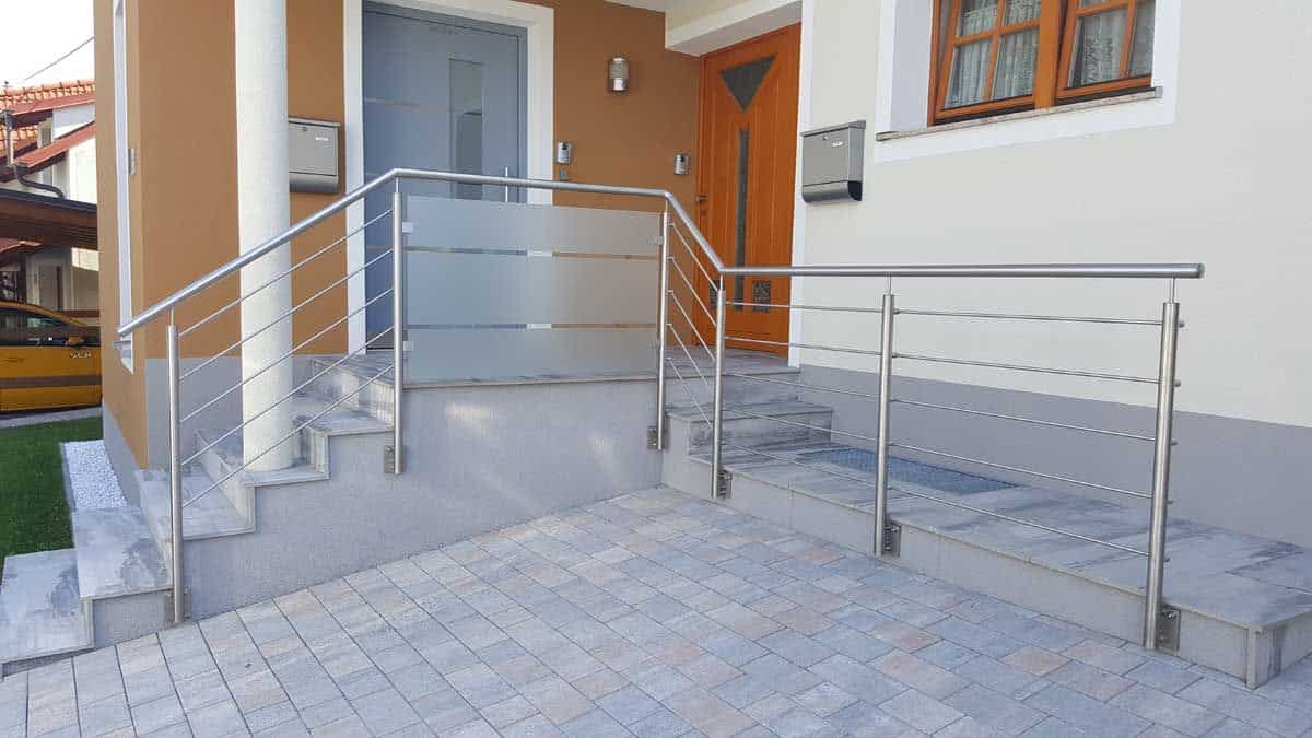 Doppelhauseingang mit zweiseitigen Aussentreppen und einem Geländer mit Querstreben und einem Glaseinsatz mit satiniertem Glasmuster von Glaserei Hohl.