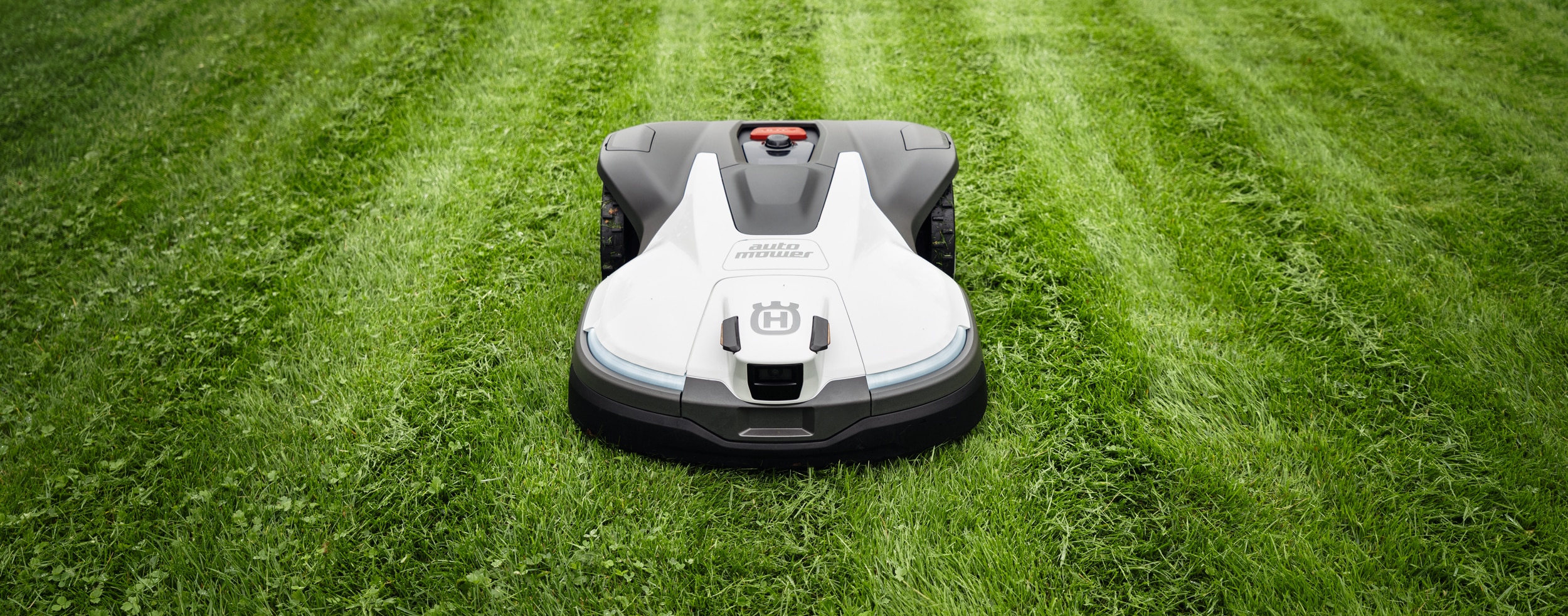 Ein moderner Mähroboter der NERA-Serie von Husqvarna pflegt den Rasen präzise und gleichmäßig.