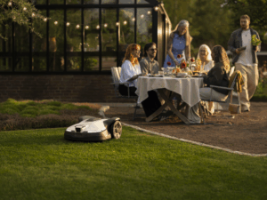 Die NERA 430V und 450V von Husqvarna pflegen den Rasen leise und effizient, während die Menschen entspannte Momente im Garten genießen.