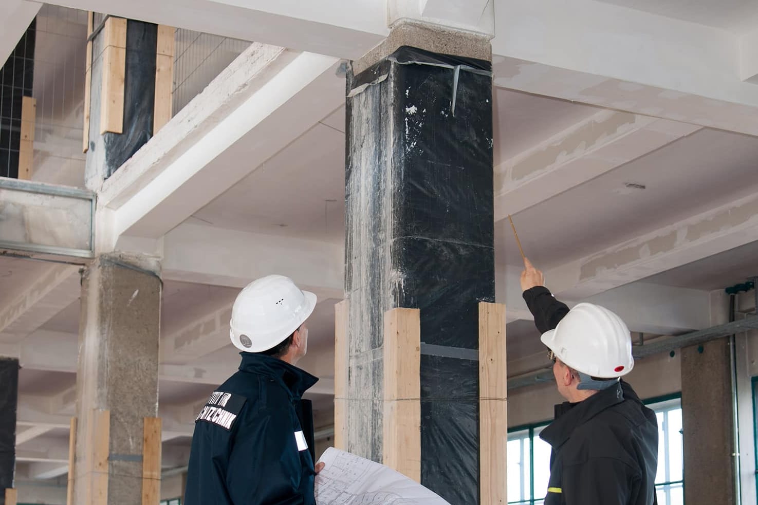 IBS Technisches Büro zeigt wie ein Techniker einen Bauplan besprechen und das Brandschutzkonzept kontrollieren.