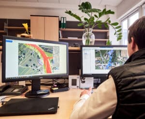 IBS Technisches Büro zeigt eine Simulation von Oberflächenwasser in einer Siedlung bei Hochwasser auf einem Computerbildschirm.