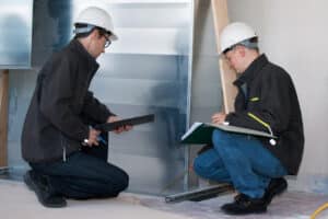 IBS Technisches Büro zeigt zwei Techniker bei der Qualitätssicherung des baulichen Brandschutzes auf einer Baustelle.