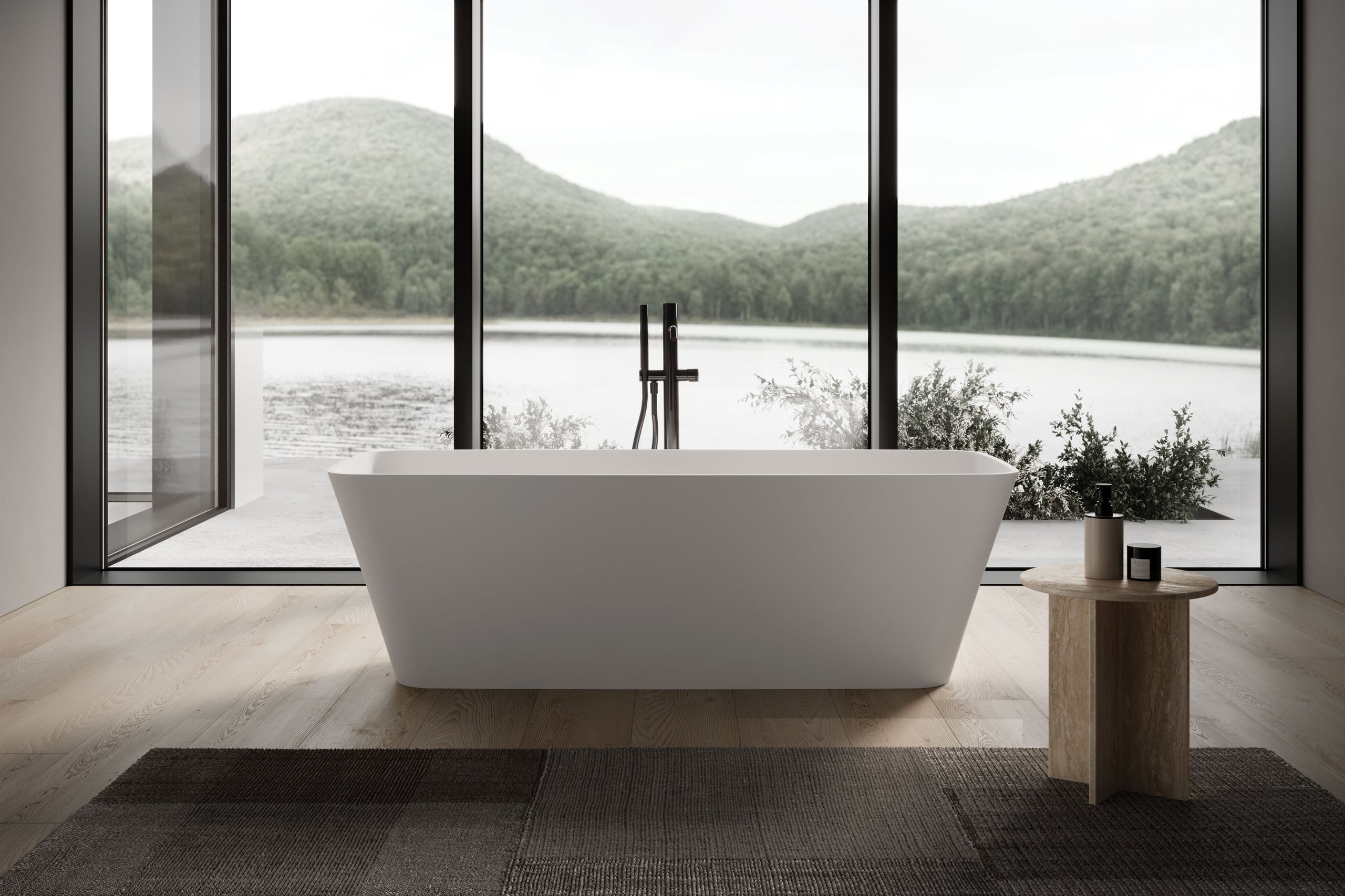 Freistehende rechteckige Badewanne mit klarer, geometrischer Linienführung und sanft zulaufender Form, mit schwarzer freistehender Armatur mit Stabbrause, positioniert vor einer raumhohen Fensterfront mit Blick auf die Natur auf einem Naturparkett mit freiliegendem Teppich und Beistelltisch von Disenia.