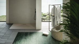 Begehbare Dusche mit bodengleicher moderner Duschtasse in hellem Beige, mattschwarzer Armatur, einem passenden stummen Diener und modernem Stabfliesenboden von Disenia.