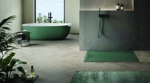 Modernes Bad mit grüner bodengleicher Duschtasse, Glaswand, Marmorwand, schwarzer Armatur, grüner freistehender Badewanne und Fischgrätboden von Disenia.