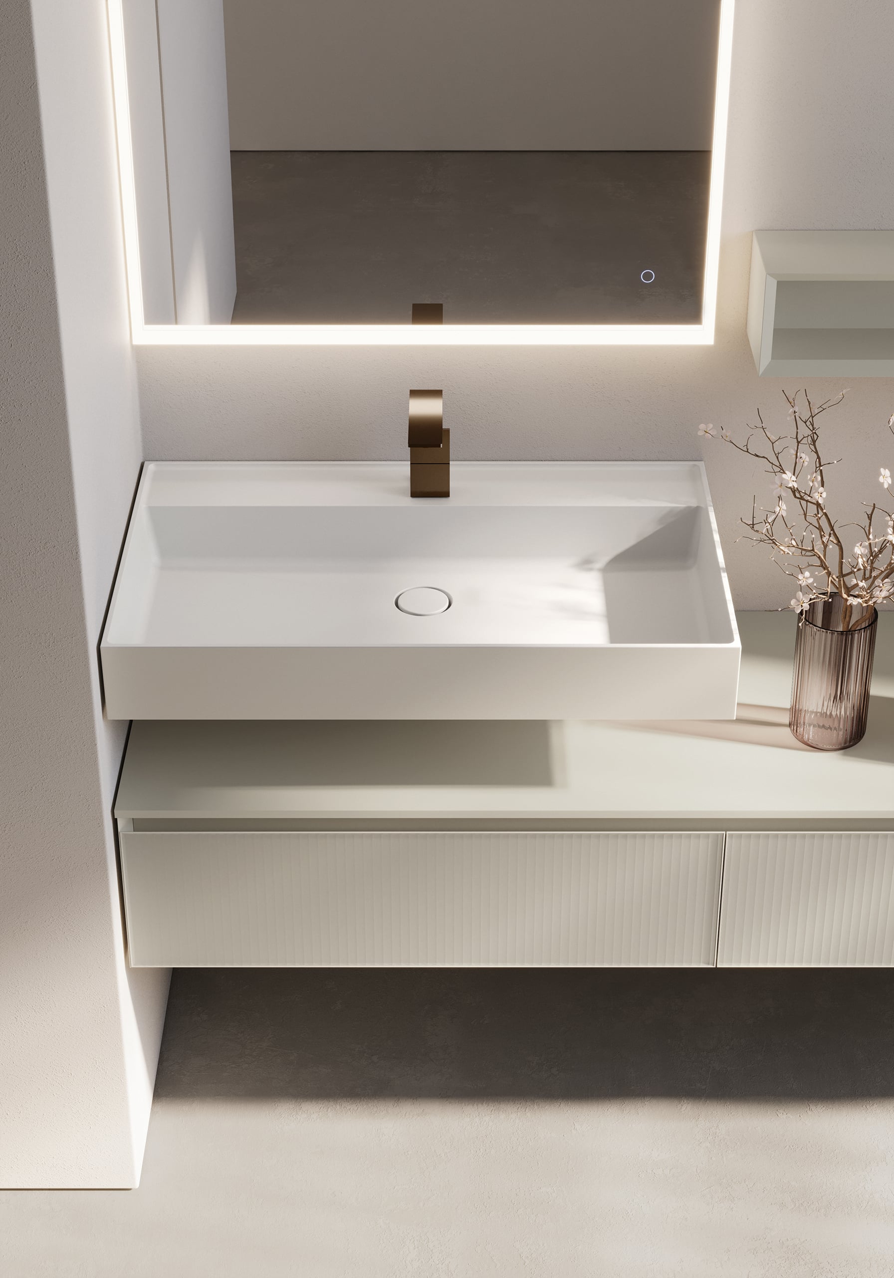 Ideagroup präsentiert einen Waschtisch mit weißem Waschbecken, einen Unterbauschrank mit gerillter Oberfläche und einen quadratischen Spiegel mit integrierter Beleuchtung.