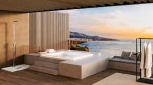 Der rechteckige Whirlpool "Helba 210" in der Unterbau-Version auf einer riesigen überdachten Terrasse mit Outdoordusche und Glasgeländer - hineingebaut in ein Podest in Steinoptik mit Treppen und Sitzbereich, von Disenia.