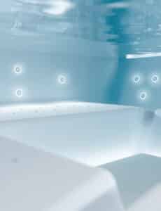 Ein rechteckiger Outdoor-Whirlpool "Helba 210" mit Unterwasser-Beleuchtung, ergonomischen Sitzmulden, Hydromassage-Düsen von Disenia.