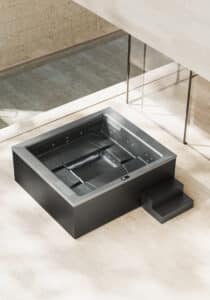 Der rechteckige Outdoor-Whirlpool "Helba 240" mit schwarzer Ummantelung mit zwei Stufen, silbernem Innenleben, Tochscreen-Panel, Hydromassagedüsen und Einstiegshilfen bzw. Sitzflächen am Rand mit matter Oberfläche von Disenia.