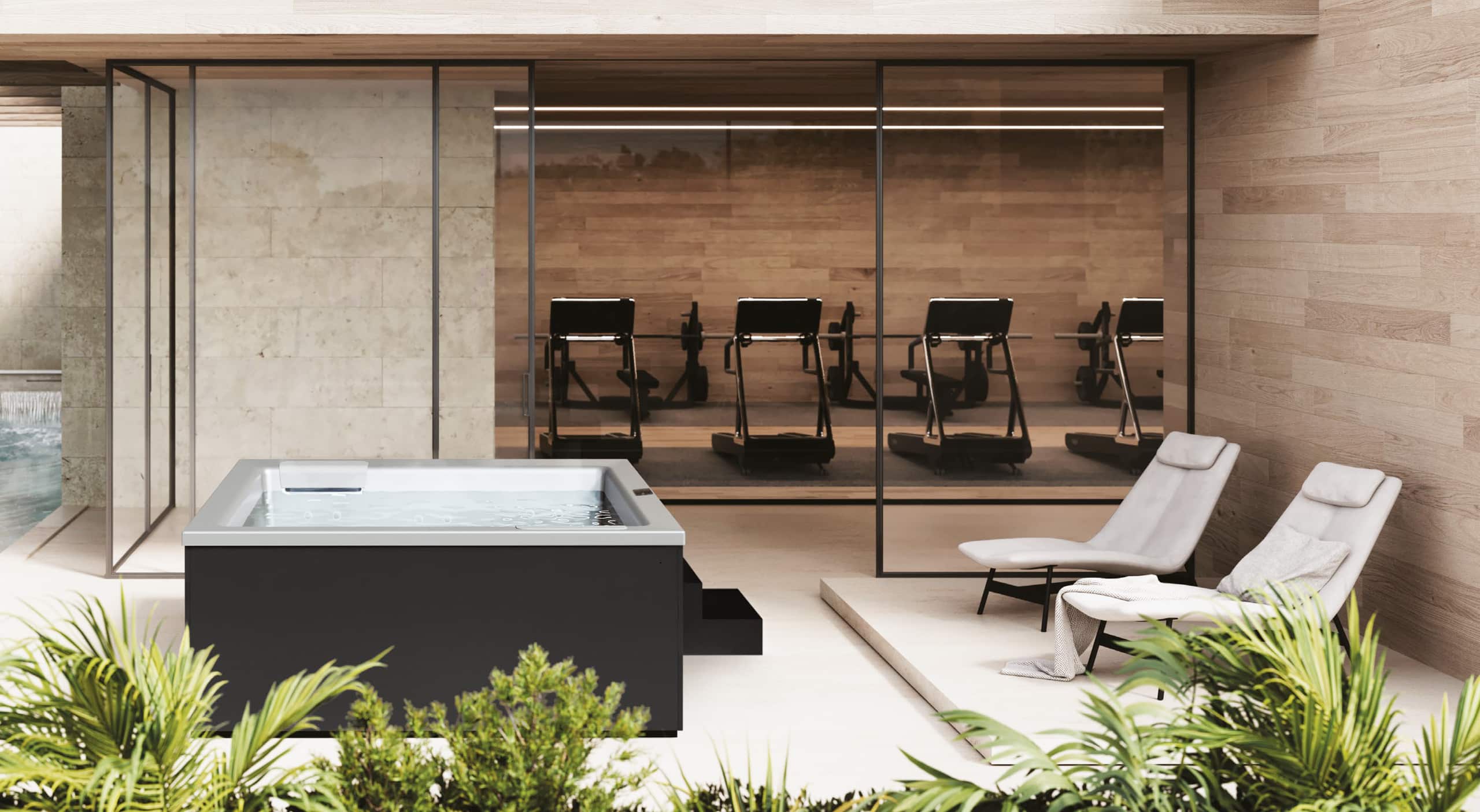 Ein Outdoor-Welnnessbereich mit Whirlpool "Helba 240" in schwarzer Ummantelung mit zwei Stufen, silbernem Innenleben, Tochscreen-Panel, Hydromassagedüsen und Einstiegshilfen bzw. Sitzflächen am Rand mit matter Oberfläche von Disenia.