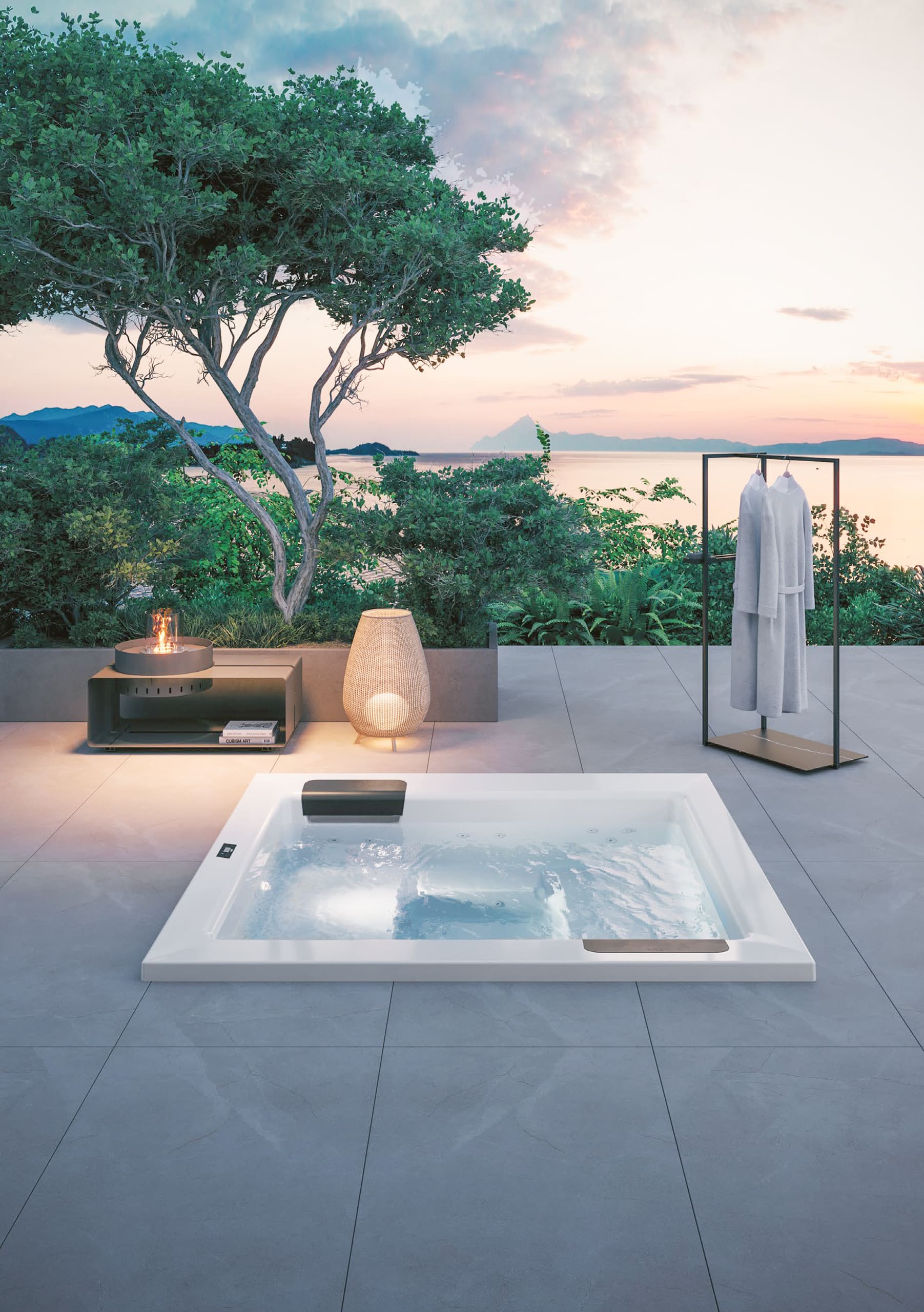 Terrasse mit XL-Steinfliesen und einer Unterbauversion des Outdoor-Whirlpools "Kyra" in Weiss mit schwarzen Nackenstützen bzw. Einstiegshilfen oder Sitzflächen am Rand mit matter Oberfläche und Touchscreen-Panel umgeben von einem stummen Diener, einer Stehlampe und einem Beistelltisch mit Feuerstelle von Disenia.