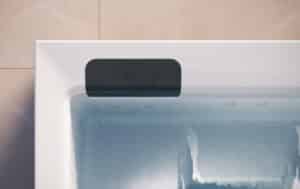 Der Outdoor-Whirlpool "Kyra" in Weiss mit schwarzen Nackenstützen bzw. Einstiegshilfen oder Sitzflächen am Rand mit matter Oberfläche von Disenia.