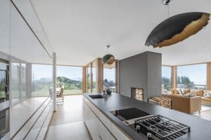 Internorm präsentiert offene Wohnküche mit Ganzglassystem mit hellbraunem Rahmen.