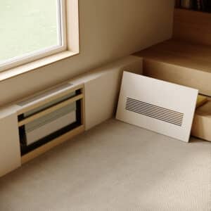 Jaga zeigt die verbaute Raumklimalösung Briza, die kühlt und heizt, als Wandeinbau in einem Wohnraum bei abgenommener Wandabdeckung.
