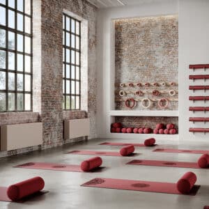 Jaga zeigt die Raumklimalösung Briza, die kühlt und heizt, in hellem Rose als Wandmontage in einem Fitnessstudio.