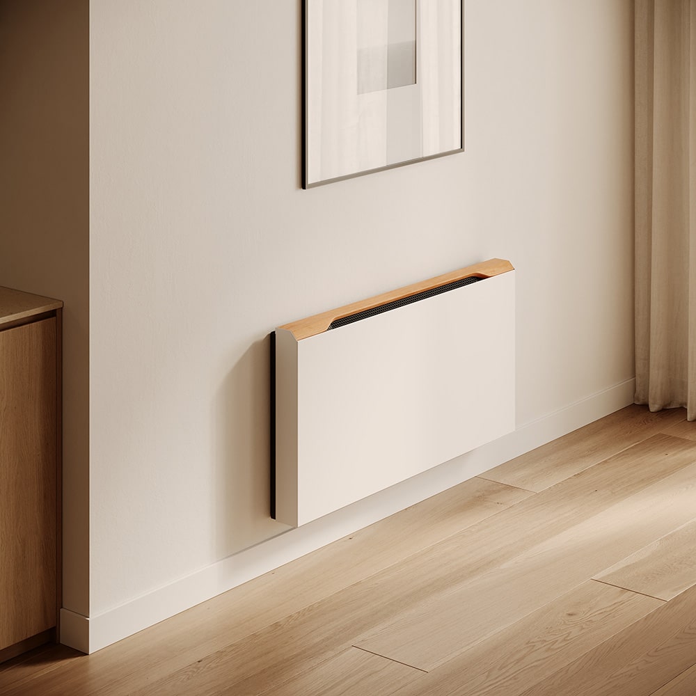 Jaga zeigt die Raumklimalösung Briza, die kühlt und heizt, in Beige als Wandmontage mit Holzabdeckung in einem Wohnraum.