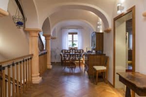 Zwischengeschoss eines Hauses mit Holztreppenhaus, Fischgrätparkett, Betonsäulen mit Stuck und einem Tonnengewölbe von JAHN Gewölbebau.