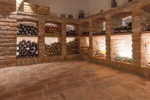 Jahn Gewölbebau zeigt einen Weinkeller mit gemauerten Weinregalen und Steinboden.