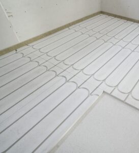 James Hardie zeigt eine Detailaufnahme von Trockenestrichelemente für Fußbodenheizung in einem Rohbau.