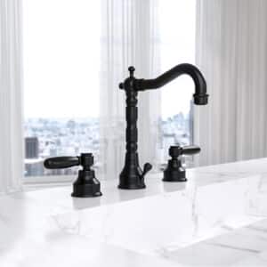 Ein marmorierter Waschtisch mit 3‑Loch‑Batterie und matt schwarzen Hebelgriffen von Jörger.