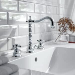 Ein Waschtisch mit 3‑Loch‑Batterie und Kreuzgriffen in Chrom von Jörger Armaturen.