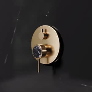 Ein 1‑Hand‑Wannenfüll‑ und Brausebatterie 'Valencia' in Edelmessing matt, Unterputz‑Montage mit schwarzem Marmorgriff von Jörger.