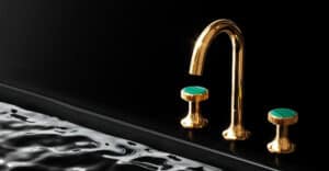 Ein Waschbecken mit 3‑Loch‑Mischer 'Valencia' in Gold mit grünem Malachit‑Element von Jörger.