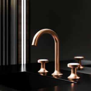 Ein Waschtisch mit 3‑Loch‑Armatur aus der Serie 'Valencia' in Rosé‑Gold, matt mit weißen Kristallen über einem schwarzen Waschbecken von Jörger.