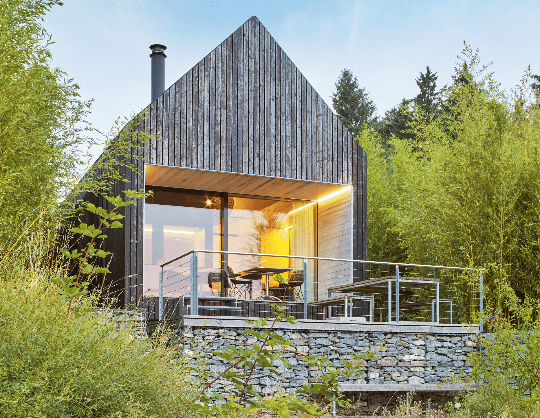 Naturverbundenes Haus mit Holz-Fassade, Terrasse, Balkon und deckenhohen Fenstern sowie einer barrierefreien Schiebetür der Serie ONE von Josko.