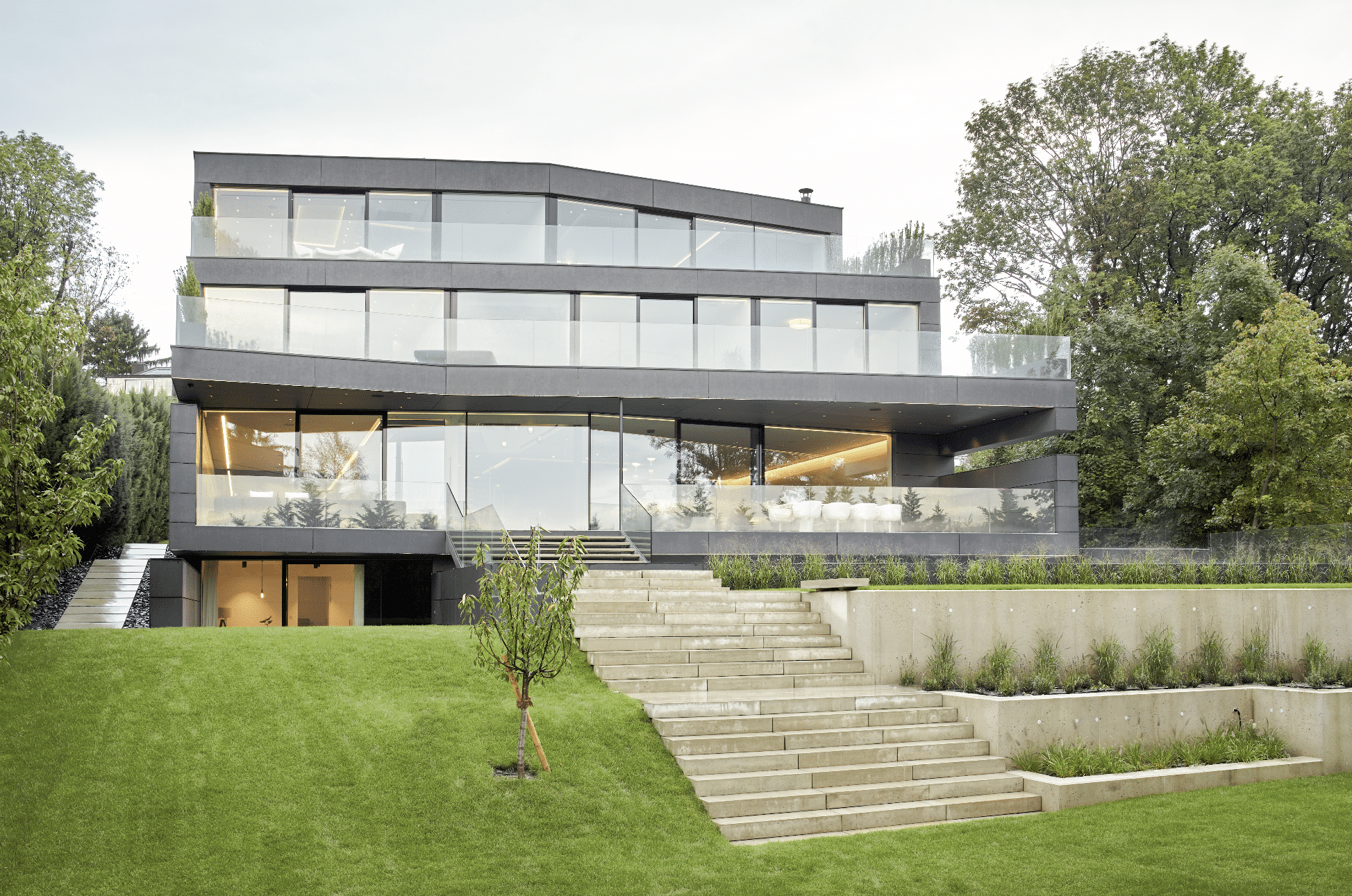 Großes Wohnhaus mit vielen Balkonen mit Glasgelendern und bodentiefen Ganzglassystemen von Josko.