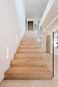 LICO zeigt eine Holztreppe mit Glasgeländer und Trittplatten aus Natureiche Synchro.