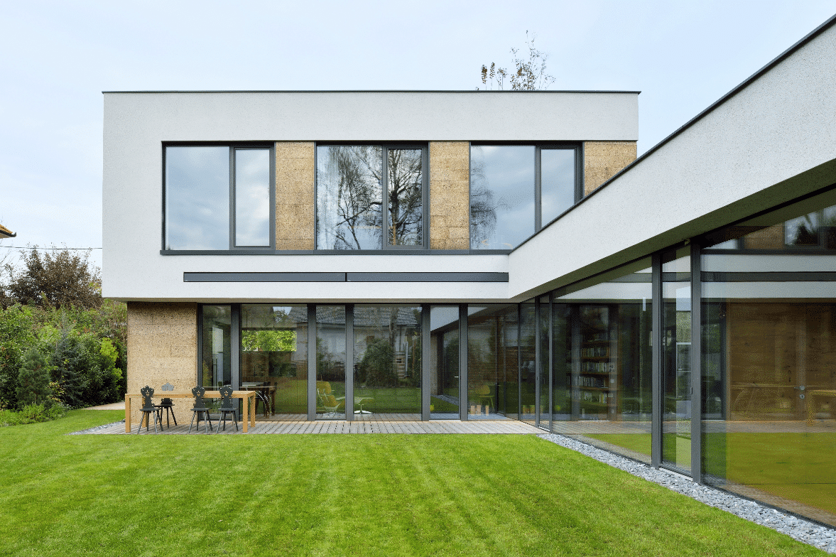 Modernes, kubisches Architektenhaus mit M SORA Vollverglasung sowie Glaswänden, teilweise ausgestattet mit deckenhohen, barrierefreien Schiebetüren zum Garten hin.