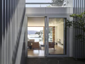 Modernes Haus mit großzügiger Terrasse und großer Terrassenschiebetür mit hellgrauem Rahmen von M SORA.